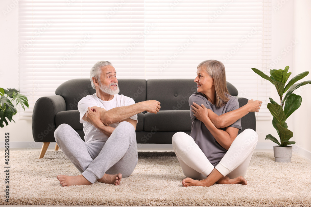 Senior couple practicing yoga on carpet at home. Healthy lifestyle Senior couple practicing yoga on carpet at home. Healthy lifestyle