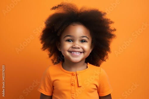 Black little girl on orange studio background, cute child portrait,