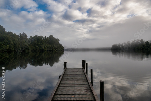 Early morning fog with low cloud at sunrise above the surface of the West Coast lake