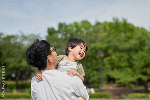公園で子供と一緒に遊ぶ父親