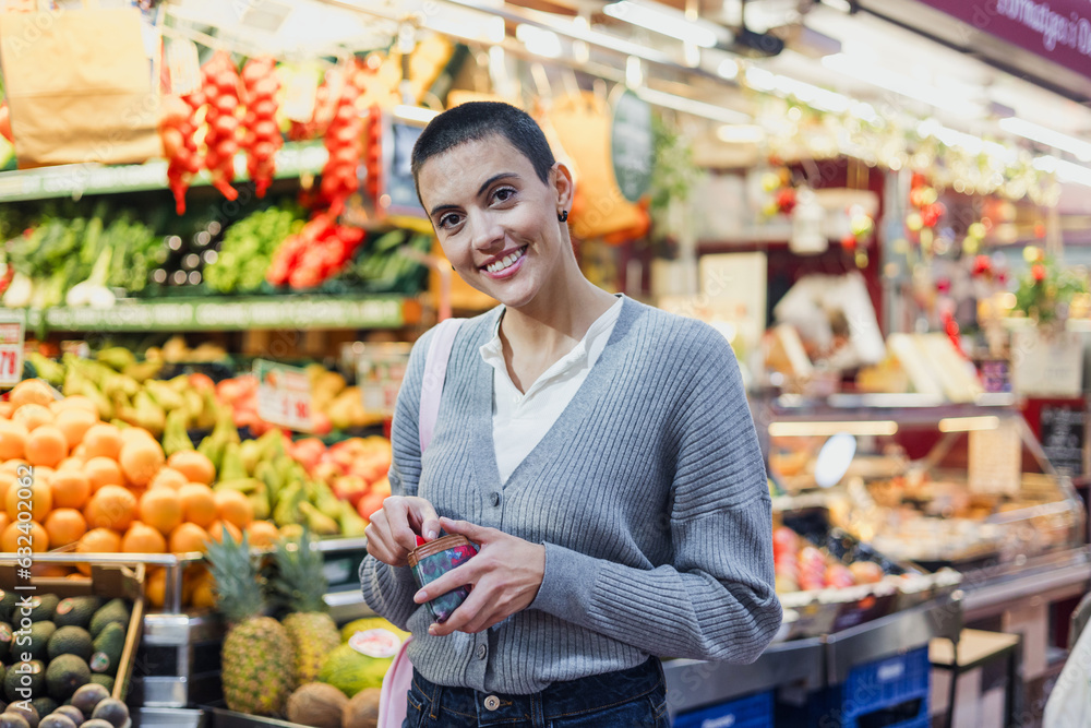 hispanic young woman with skinhead or short hair shopping vegetables on traditional market or grocery 