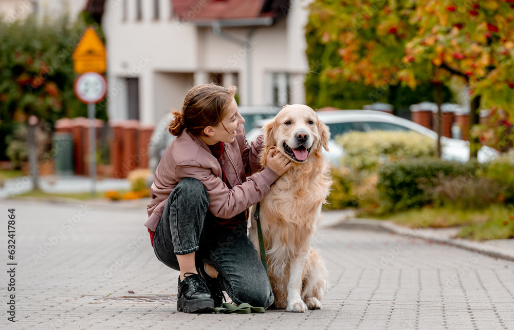 Preteen teen girl wear on golden retriever dog lace outdoors. Pretty kid child with purebred pet doggy walking at street Preteen teen girl wear on golden retriever dog lace outdoors. Pretty kid child with purebred pet doggy walking at street