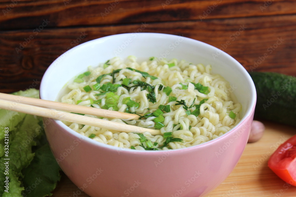 The bowl contains noodles with wooden sticks. The bowl contains noodles with wooden sticks.
