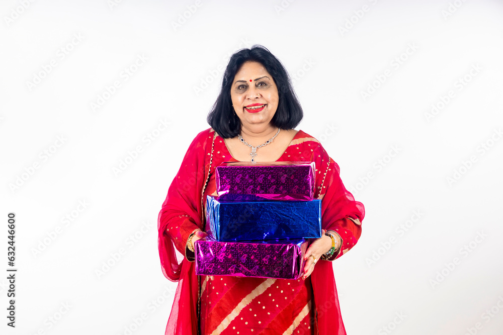 Indian older woman holding gift box in hand Indian older woman holding gift box in hand