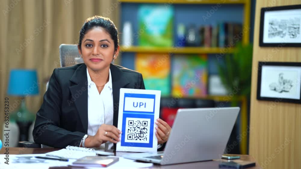 In her office, the Indian woman confidently urges everyone to streamline payments using UPI, highlighting its convenience and efficiency for smoother transactions and enhanced financial processes. In her office, the Indian woman confidently urges everyone to streamline payments using UPI, highlighting its convenience and efficiency for smoother transactions and enhanced financial processes.
