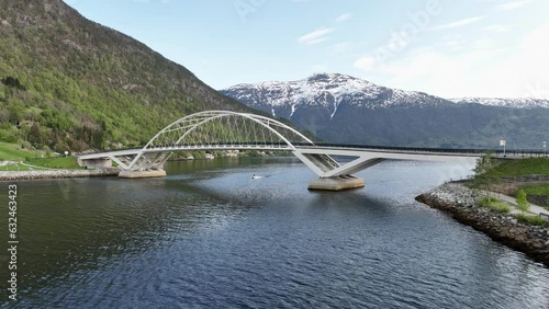 Sogndal Loftesnes bridge seen with mountain background and a small boat passing below - Norway low altitude aerial photo