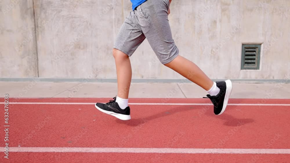 12 year old boy runs on his school's track. 12 year old boy runs on his school's track.