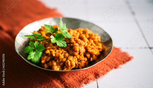 rote Linsen Essen im Teller, Schale. Zubereitet als Dal, Salat, Curry mit Kokosmilch und indischen Gewürzen. Dekorativ angerichtet mit glatter Petersilie photo