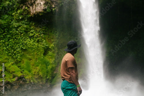 Young man looking at a waterfall