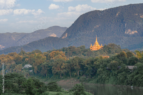 Vat Phon Phao Buddhist Temple (aka Temple of Tranquility). Situated on a hill in the southeast of Luang Prabang, Laos, across the Nam Khan River. A golden stupa used as a forest meditation retreat photo