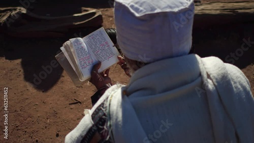 Priest praying with a bible Amhara Region Lalibela Ethiopia
