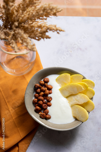 Breakfast bowl of yogurt with apple and hazelnuts	
