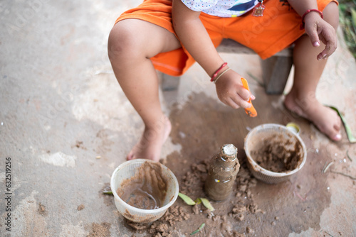 Girl playing with sand and toys on concrete floor Cute kids sand at home , creative ideas and development of imagination.