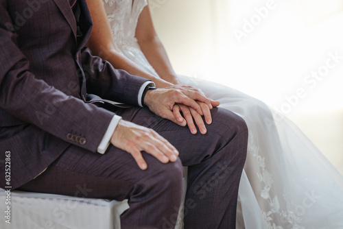 Bride and groom holding hands on their wedding day close-up