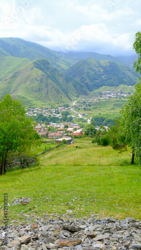 A View to Infinity: The Kazbegi Mountains Rise Above the Clouds, surrounding the small town of Kazbegi Mkinvartsveri in Georgia in a cloudy day in summer, Gudauri gergeti trinty church, ananuri