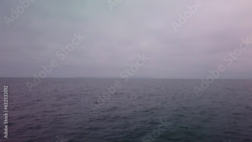 Gimbal shot from a moving boat of the open ocean with the Channel Islands barely visible in the marine layer and fog off the coast of Ventura, California. 4K photo