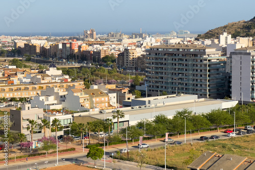 Buildings and houses in city. Sagunto Town, view of city from mountain. Roofs of houses and townhouses roofs view from of Sagunto Castle, Spain. Background the Port of Sagunto and Mediterranean Sea.