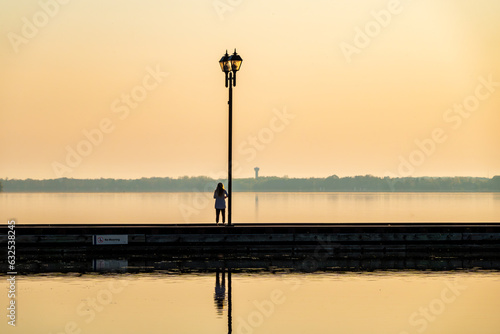 A Young Woman Takes a Moment for Meditation on the Wharf at Couchiching Beach Park in Orillia, Ontario