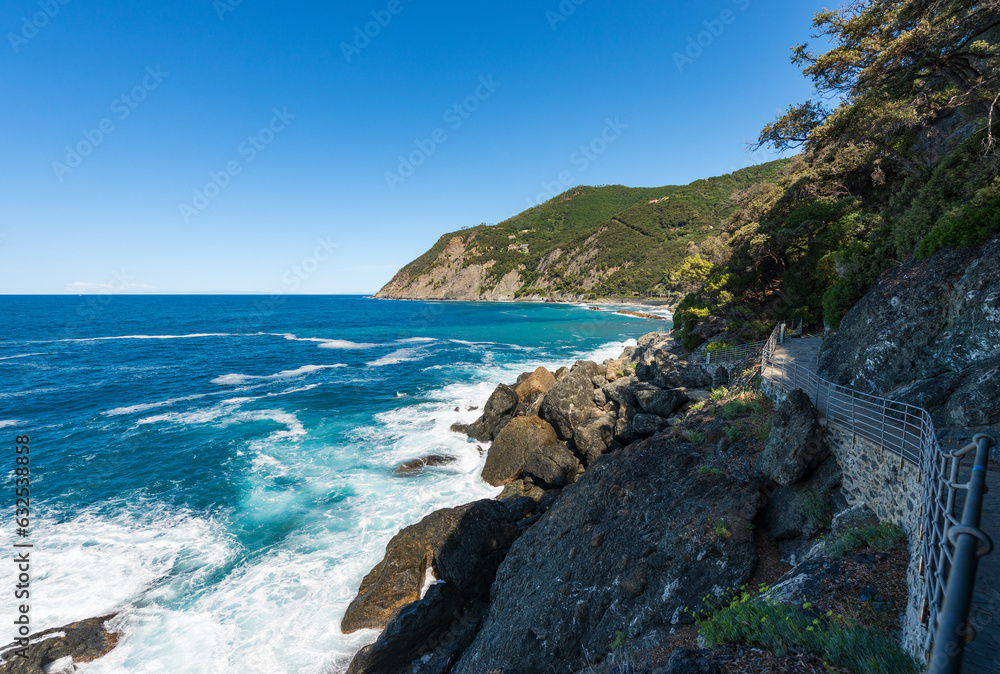 Trekking trail on the rocky coast of Liguria with cliffs and Mediterranean sea (Ligurian sea), near the small Village of Framura (Cinque Terre). La Spezia, Liguria, Italy, Europe.