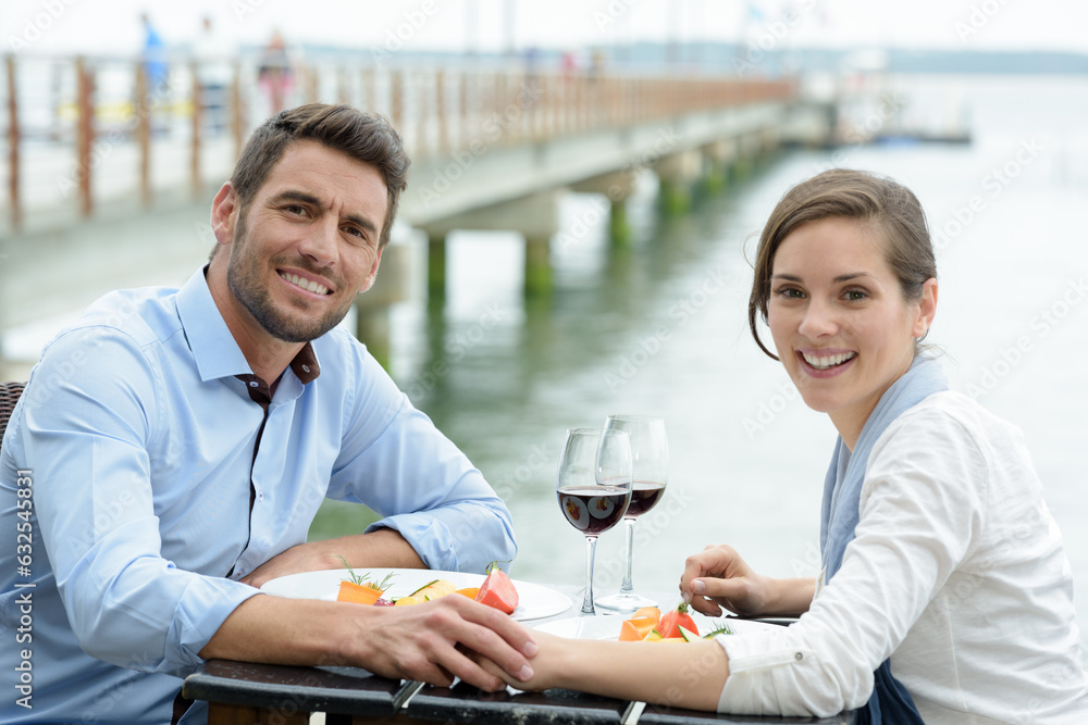 couple holding hands while having meal on terrace couple holding hands while having meal on terrace