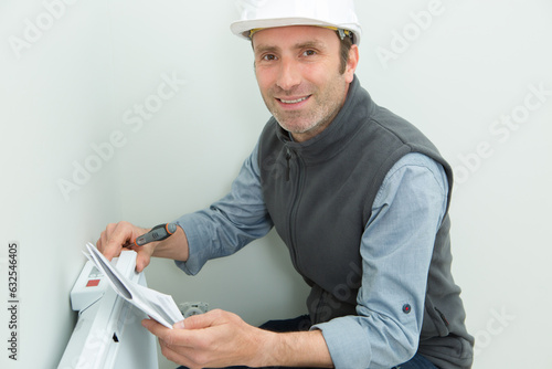 portrait of handyman fixing the radiator