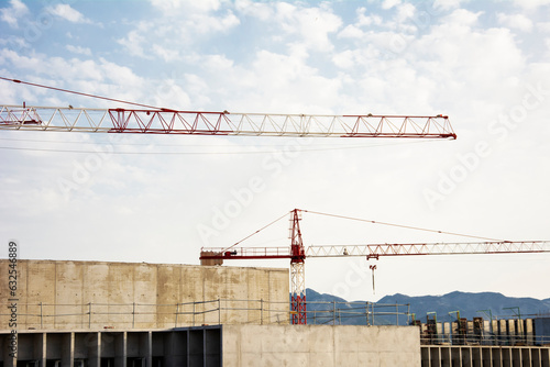 Building under construction with large tonnage cranes with the blue sky background photo