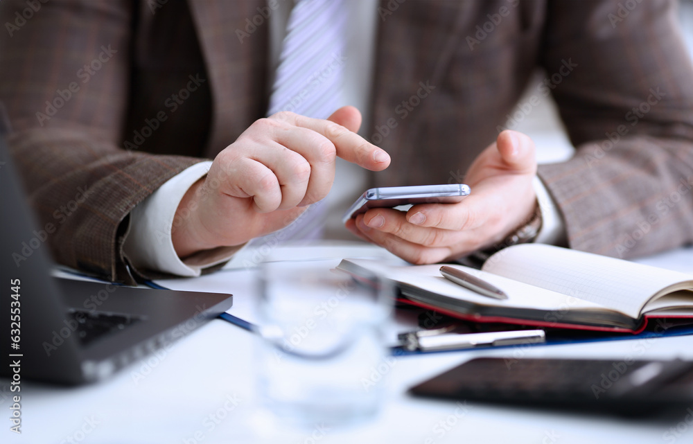 Male arm in suit hold phone and silver pen at workplace closeup. Read news mania send sms chat addict use electronic bank modern lifestyle job plan colleague share blog tweet web application search Male arm in suit hold phone and silver pen at workplace closeup. Read news mania send sms chat addict use electronic bank modern lifestyle job plan colleague share blog tweet web application search