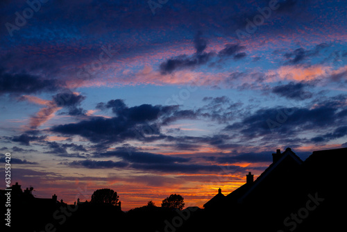 Sunset in Norfolk  United Kingdom.  Gold and blue sky over rooftops. 