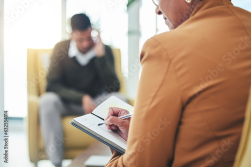 Psychologist writing, man stress and sofa with woman, therapy and listen for mental health, mindset or care. Psychiatrist, depressed patient and frustrated in clinic, notebook and help for anxiety photo