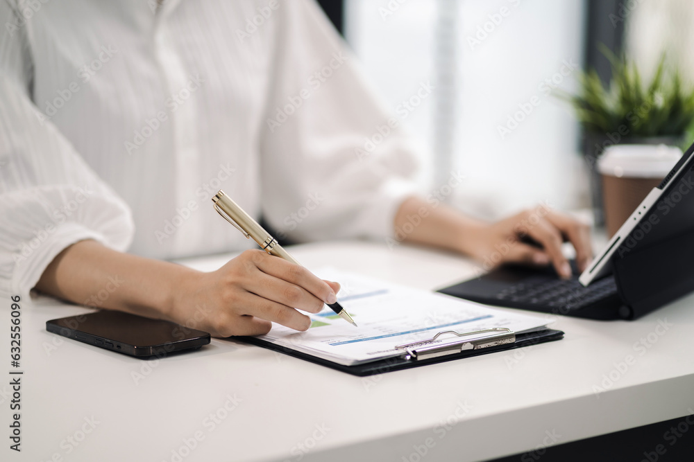 Women work on laptop on the table at the office with information documents. Women work on laptop on the table at the office with information documents.