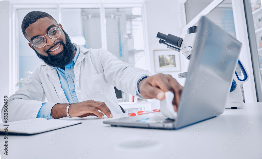 Obraz premium Wiping keyboard, research and a scientist or man in a lab, working and disinfectant for a laptop. Happy, healthcare and a doctor or an employee cleaning a computer of a virus for medical safety