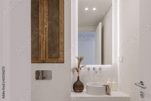 Aesthetic wabi sabi bathroom interior design in brown and off white shades with solid oak and rattan furniture. Microcement in bathroom. Slow living concept