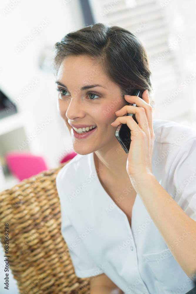 beautician taking telephone call on smartphone beautician taking telephone call on smartphone