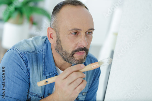 man touching up the wall with a paintbrush