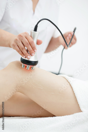 RF body cavitation lifting procedure in a beauty salon. Ultrasound therapy to reduce fat and elasticity of the skin. Cosmetic ultrasonic anti-cellulite massage close-up