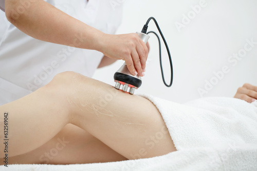 RF body cavitation lifting procedure in a beauty salon. Ultrasound therapy to reduce fat and elasticity of the skin. Cosmetic ultrasonic anti-cellulite massage close-up