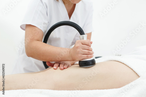 RF body cavitation lifting procedure in a beauty salon. Ultrasound therapy to reduce fat and elasticity of the skin. Cosmetic ultrasonic anti-cellulite massage close-up