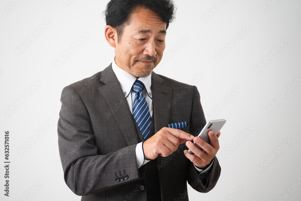 笑顔でスマートフォンを操作しているミドル男性 ビジネスイメージ 笑顔でスマートフォンを操作しているミドル男性 ビジネスイメージ