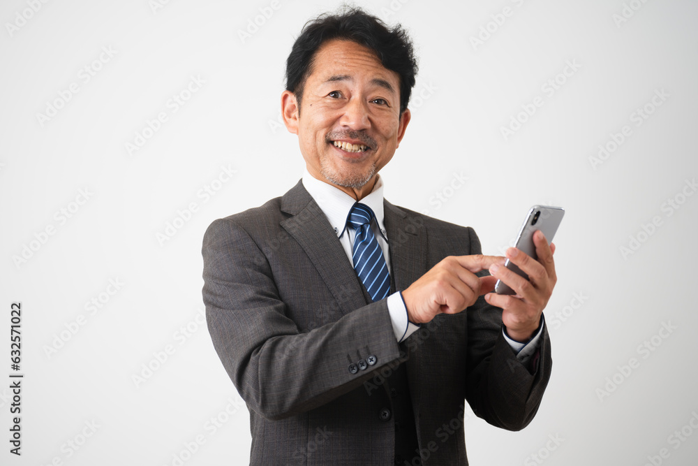 笑顔でスマートフォンを操作しているミドル男性　ビジネスイメージ