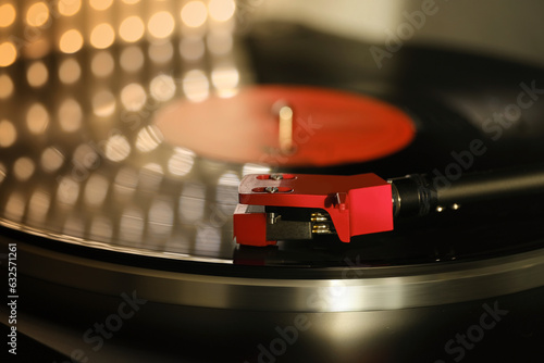 close-up of pickup head on vinyl record, color illumination, analogue retro music concept, hobby of collecting vinyl music discs, audio experience, relaxation, musical enjoyment, vintage technology photo