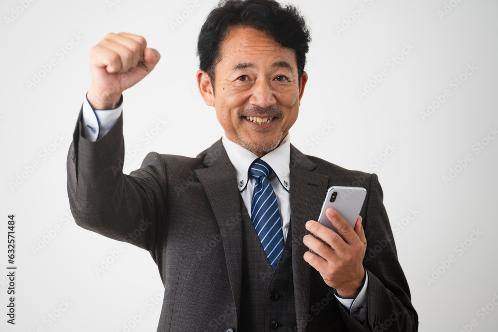 スマートフォンを持ってガッツポーズをするミドルだんせい　ビジネスイメージ