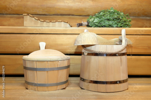 Sauna and bath accessories are on a wooden bench in the interior of sauna. 