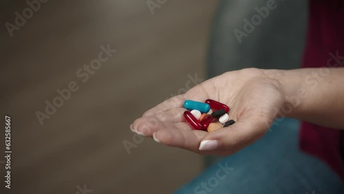 Close up shot of a woman hand, many colorful pills and capsules falling into her open palm. Slow motion photo