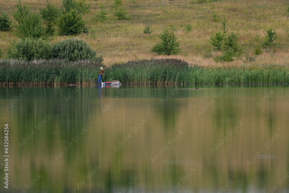 nature, lake, ducks swim, a man on the opposite bank catches fish, a lot of green grass nature, lake, ducks swim, a man on the opposite bank catches fish, a lot of green grass