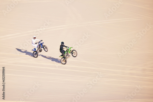 Motorcycle, sand and sports with people in the desert for adrenaline, adventure or training in nature. Bike, summer and freedom with friends outdoor together to wheelie while riding on mockup space