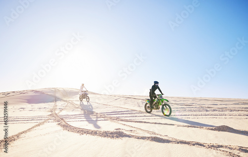 Bike, sports and race with people in the desert for fitness or an adrenaline hobby for freedom. Motorcycle, training and summer with athlete friends riding a vehicle in Dubai for energy or balance