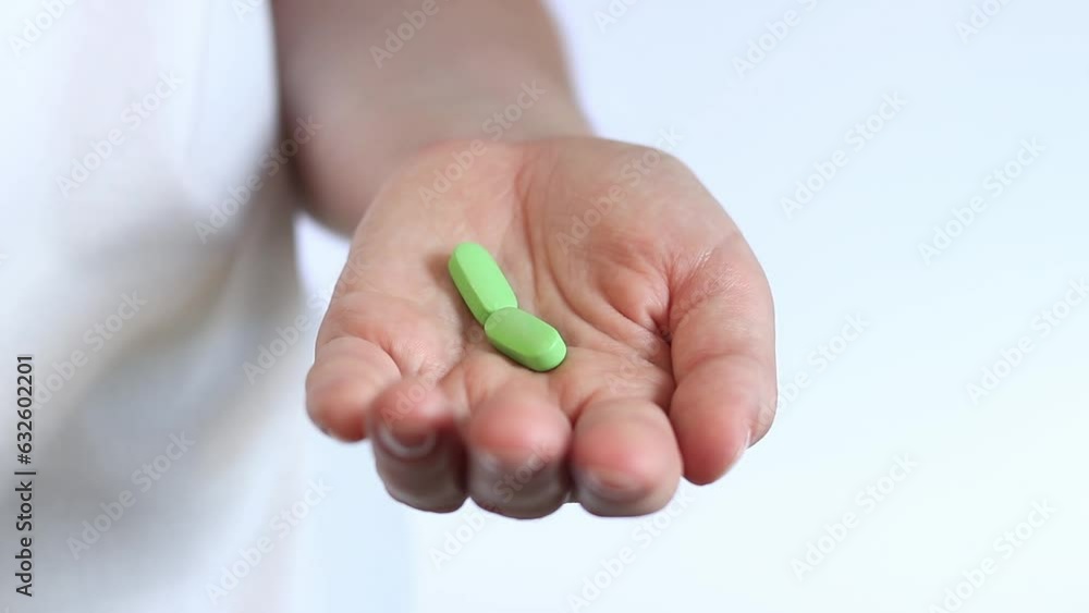 Pour the tablets from the white bottle into your hand. Vitamins and dietary supplements close-up. Daily dose of vitamins Pour the tablets from the white bottle into your hand. Vitamins and dietary supplements close-up. Daily dose of vitamins