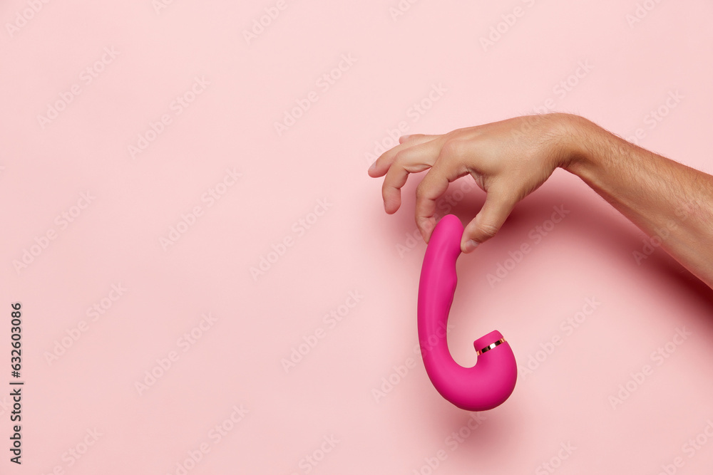 Lady's hand with vibrator, medical massager over pastel pink background. Image for sex shop. Concept of woman health, medicine, ad Lady's hand with vibrator, medical massager over pastel pink background. Image for sex shop. Concept of woman health, medicine, ad