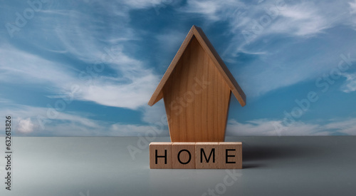 concept of home or house buying ,first time buyer .wooden house with home against a blue sky