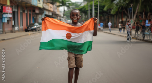 Un enfant nigérien tenant le drapeau de la république du Niger entre ses mains